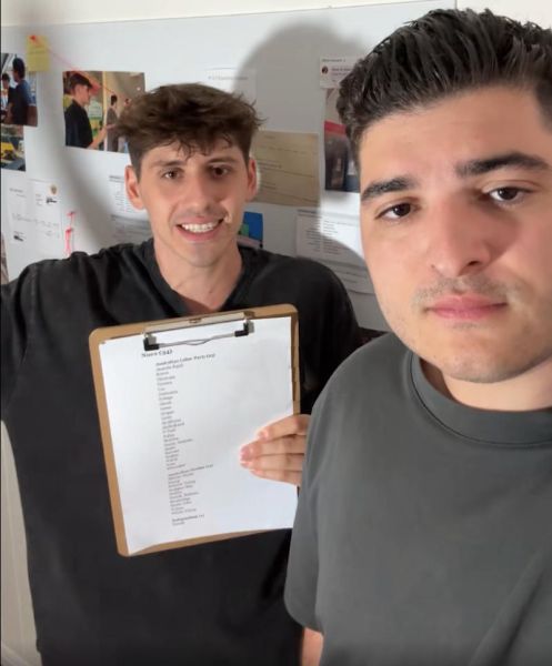 Two campaigners hold a list of senators who voted against a proposed NDIS fraud inquiry.